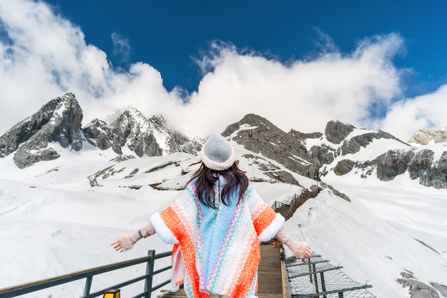 Chica con poncho disfrutando del paisaje montanesco